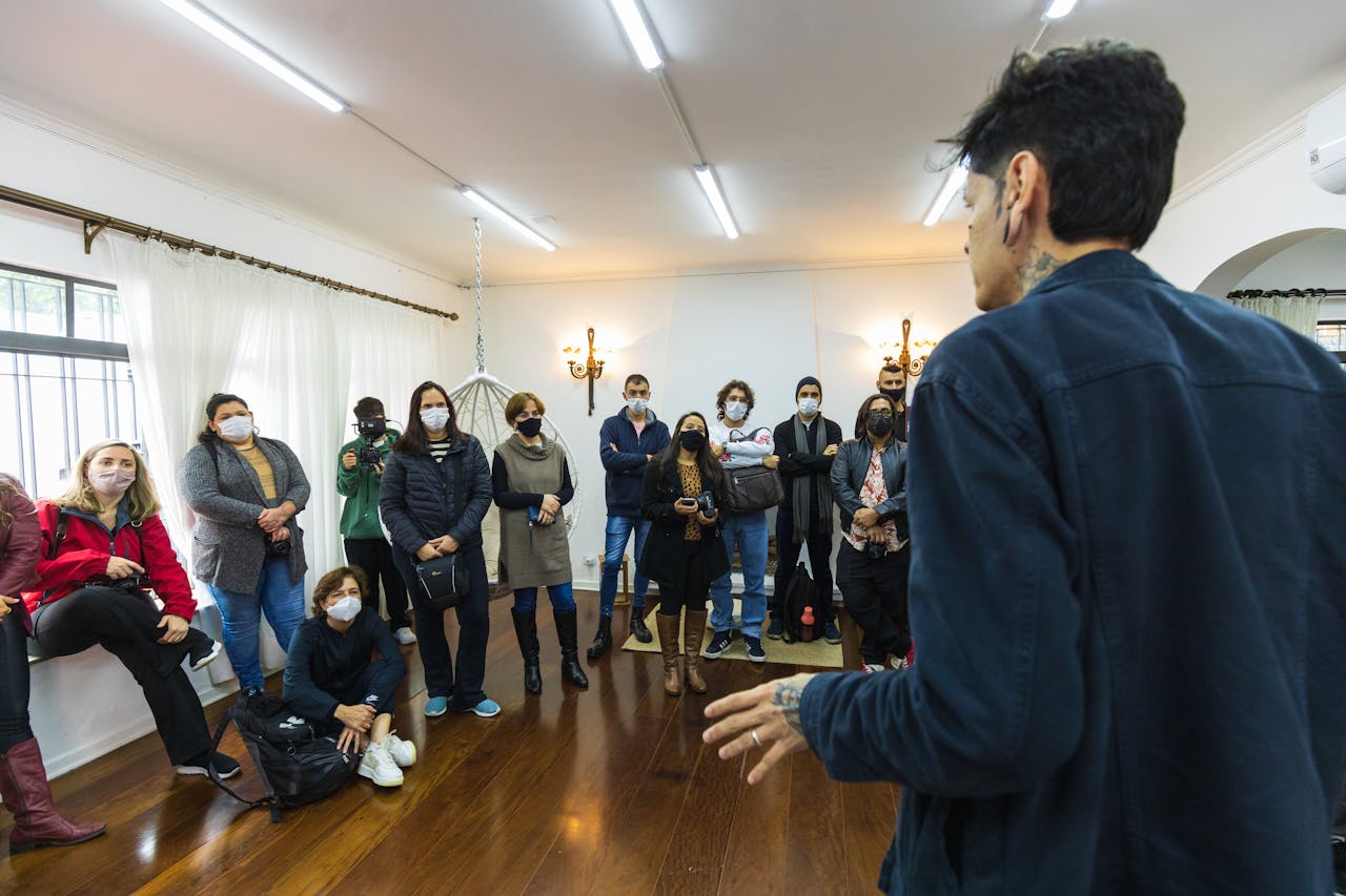 Man standing at a small-town meeting while neighbors listen attentively, capturing democratic participation