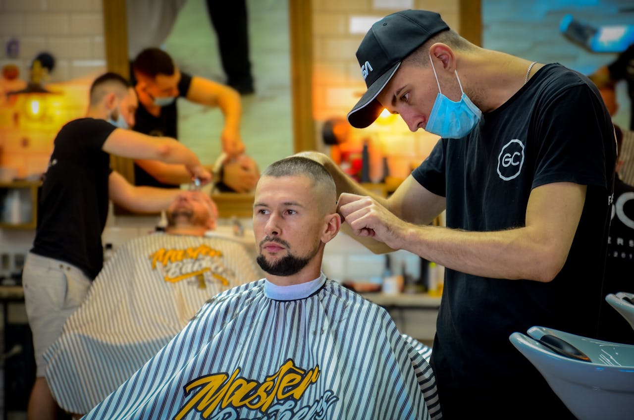 Barber carefully working on a customer’s hair in a classic shop, emphasizing focus and tradition