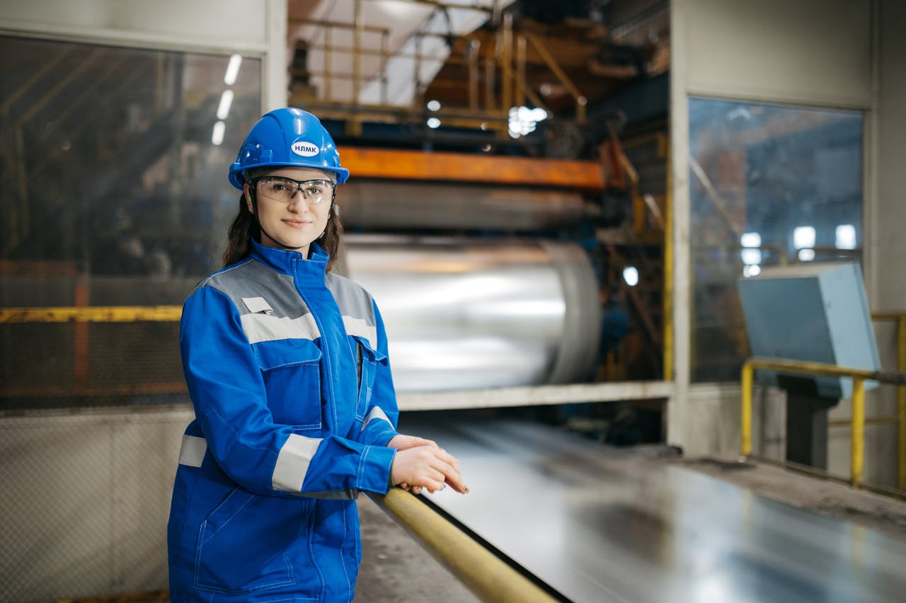 Woman in factory clothing focused on industrial work, demonstrating strength and determination