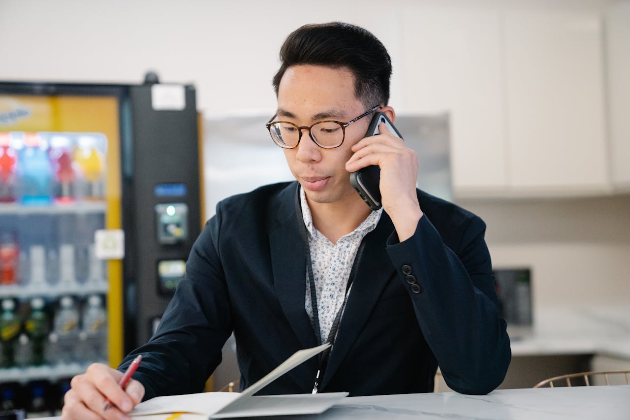 Candidate glancing at their watch while holding a phone on the desk, signaling impatience or distraction.