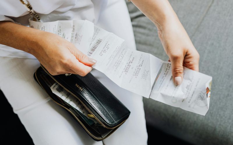 Traveler reviewing airline receipt showing added fuel surcharge