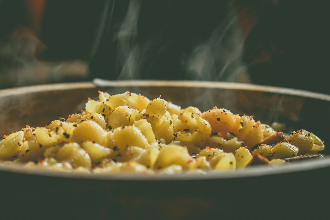 Large serving spoon in a bubbling hotdish casserole, showing a hearty, filling meal ready to serve a crowd.