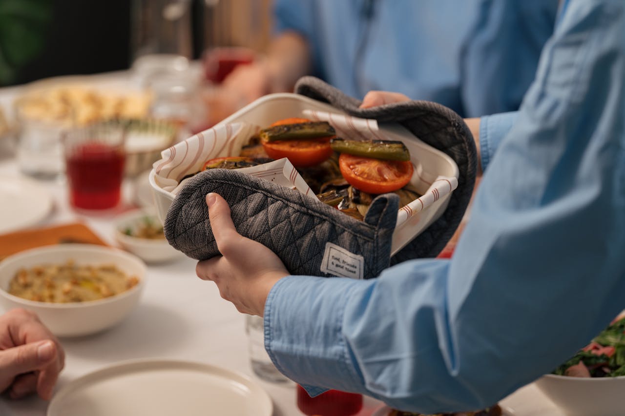 Large casserole of hotdish on a dining table with multiple plates and utensils ready for serving, ideal for family meals.