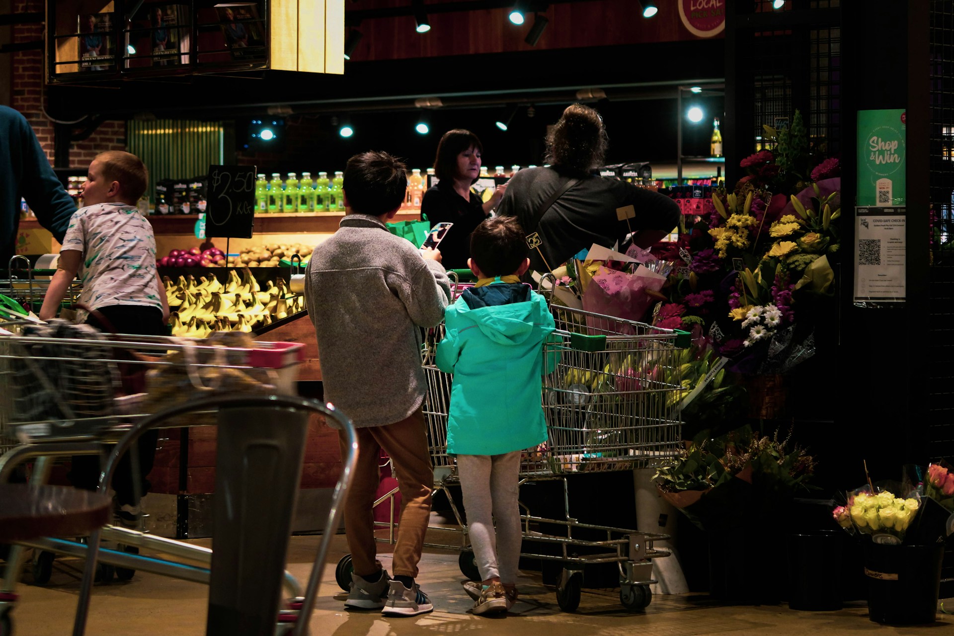 Shopper blocking a supermarket aisle with a cart while other customers wait
