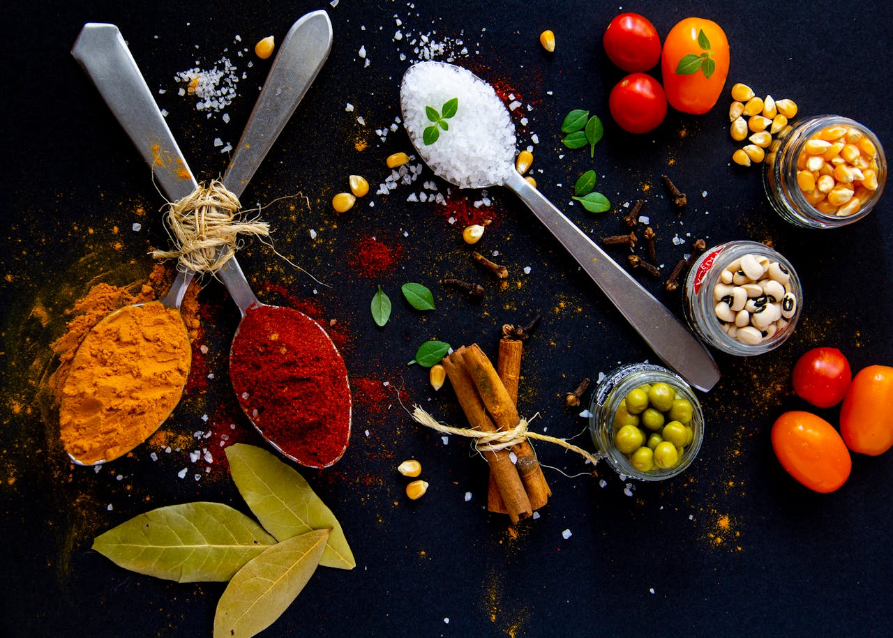 A variety of spice jars, some open, showing the vibrant colors and textures of spices.
