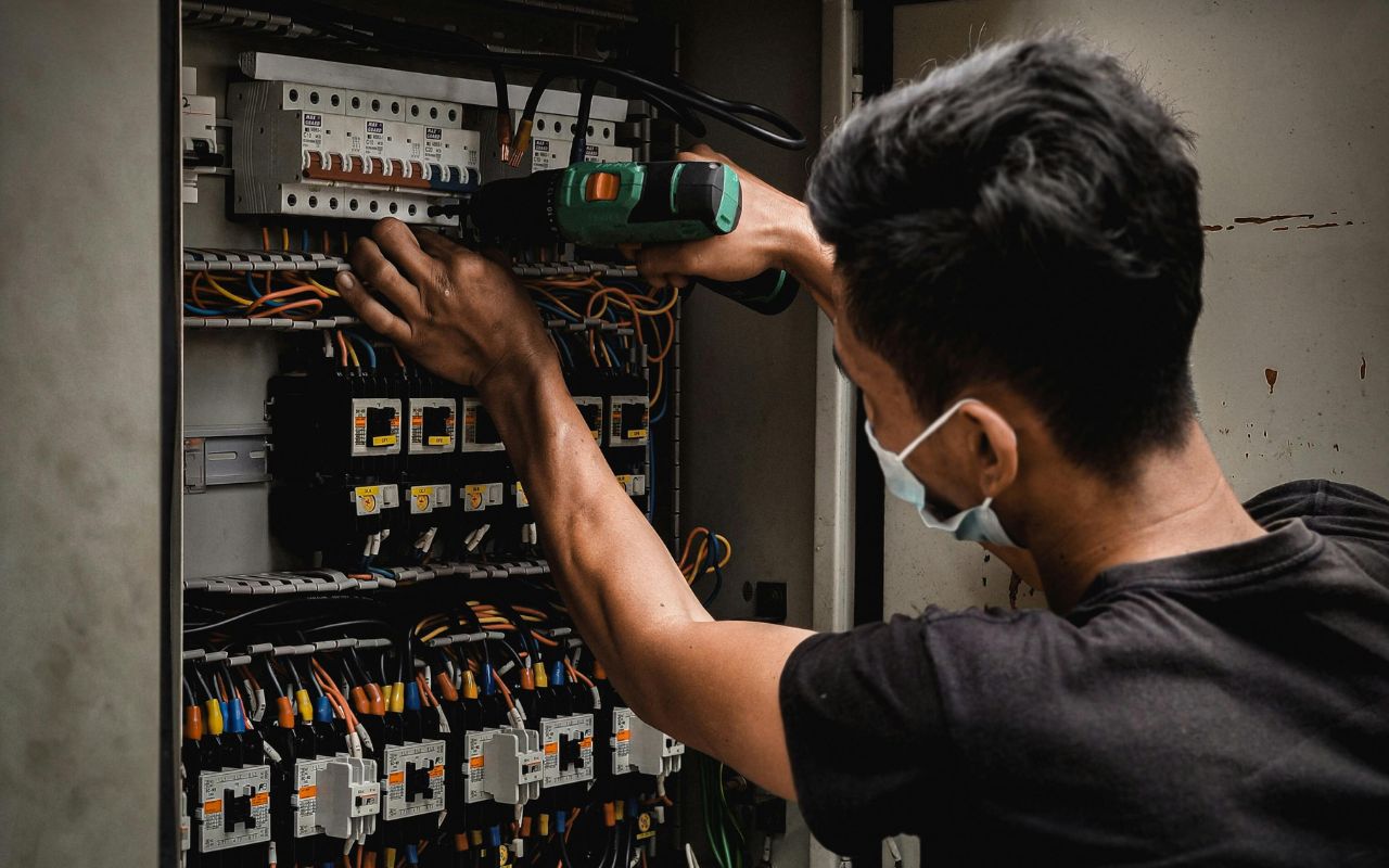 Homeowner tests wires with a voltage tester before working on a breaker panel.