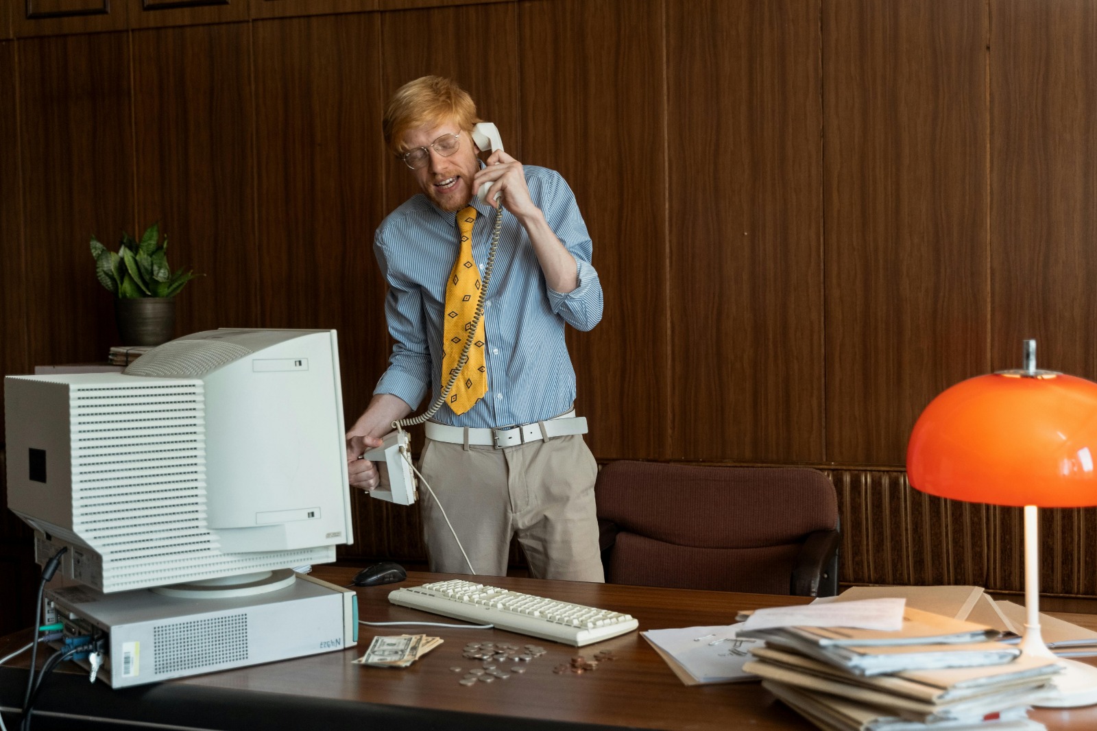 Person picking up rotary phone urgently during another person’s casual conversation.