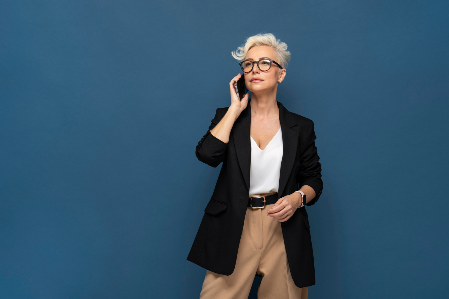 Woman over 60 wearing a structured blazer with dark wash straight-leg jeans and a simple white tee