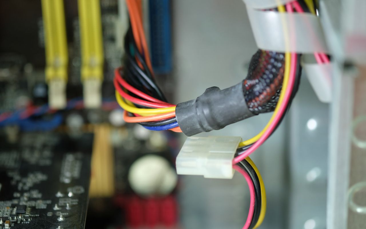 Electrical wires with tape compared to secure wire nuts inside a junction box.