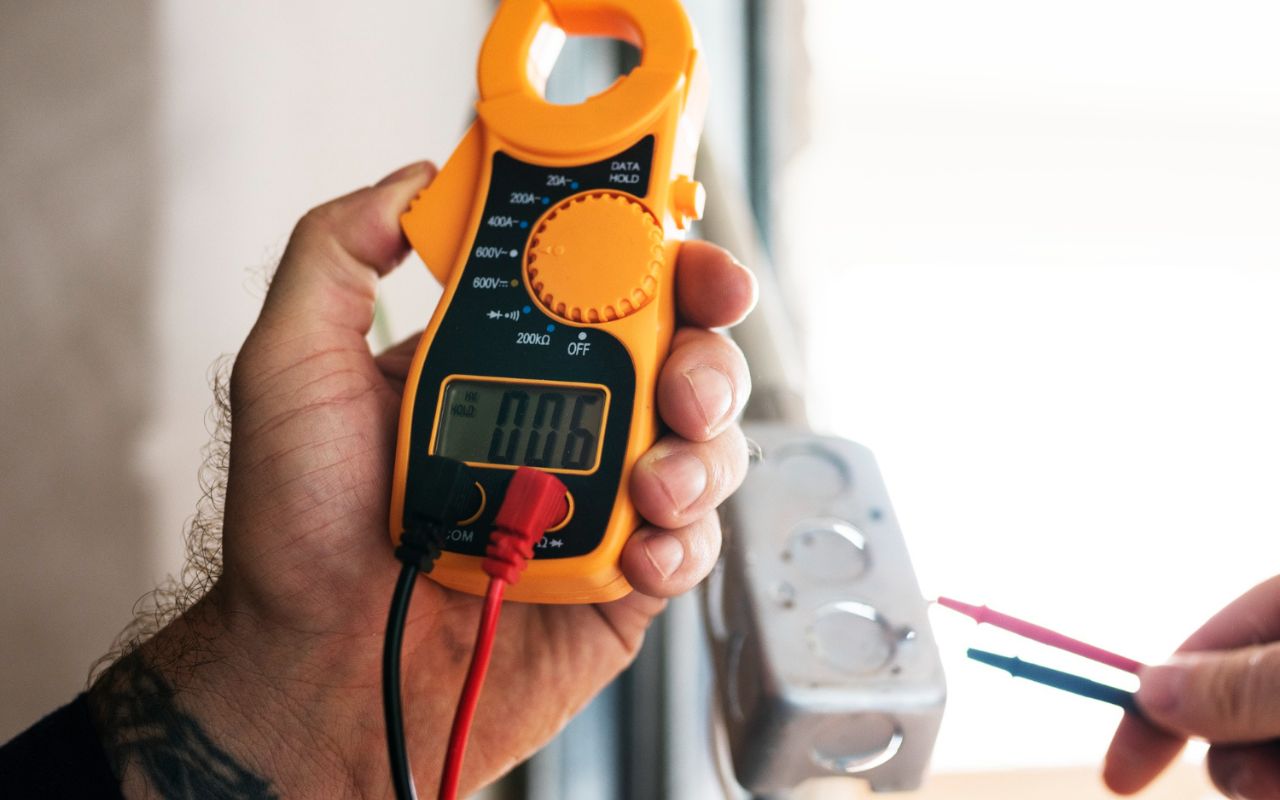 Outlet tester detects reversed hot and neutral wires in a wall outlet.