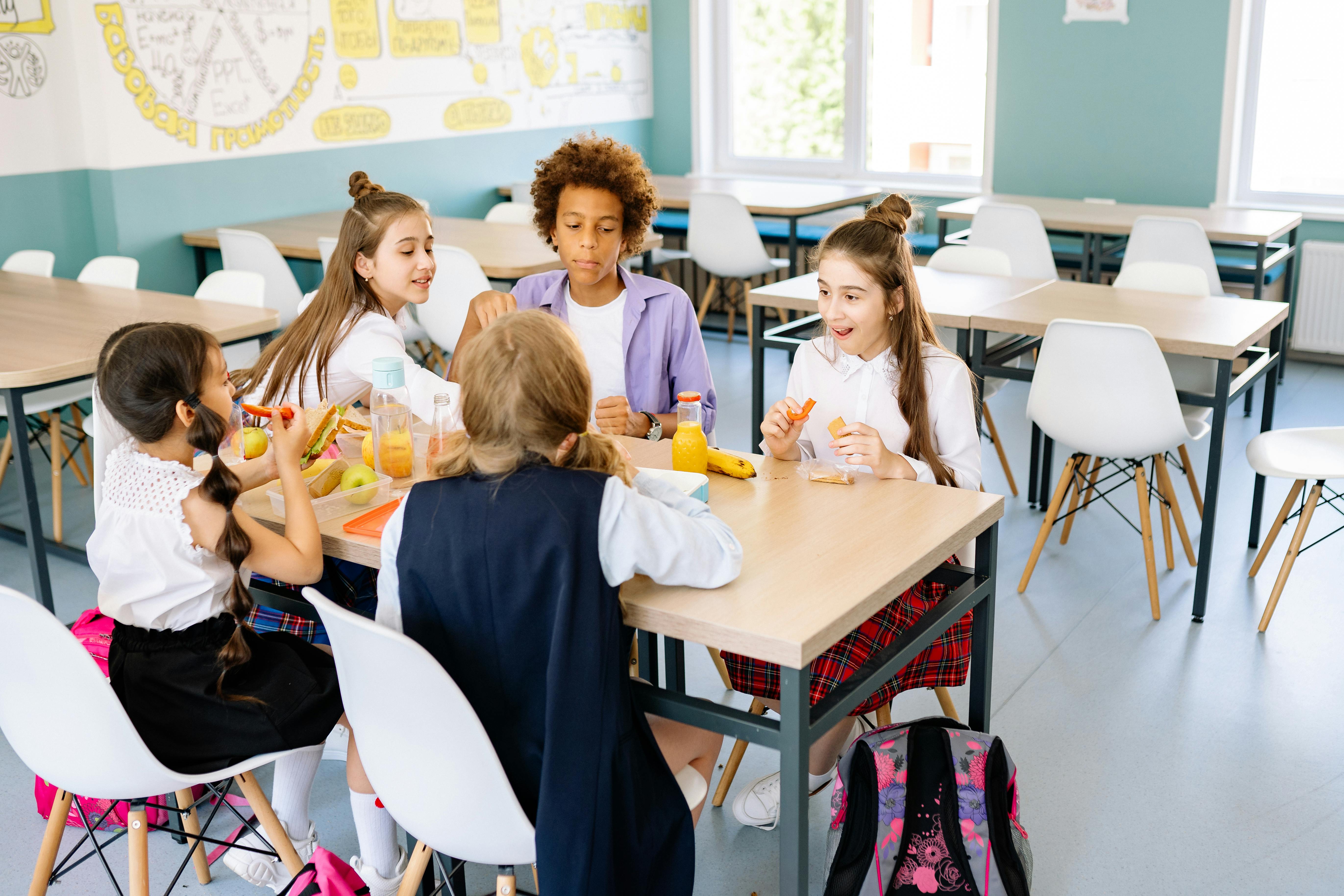 Students eat allergy-friendly lunches in a colorful U.S. school cafeteria with safety posters on the walls