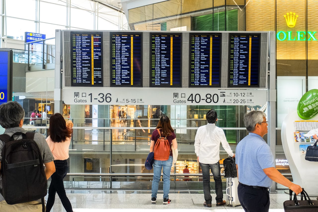 Passenger checking airport monitor displaying a last-minute gate change