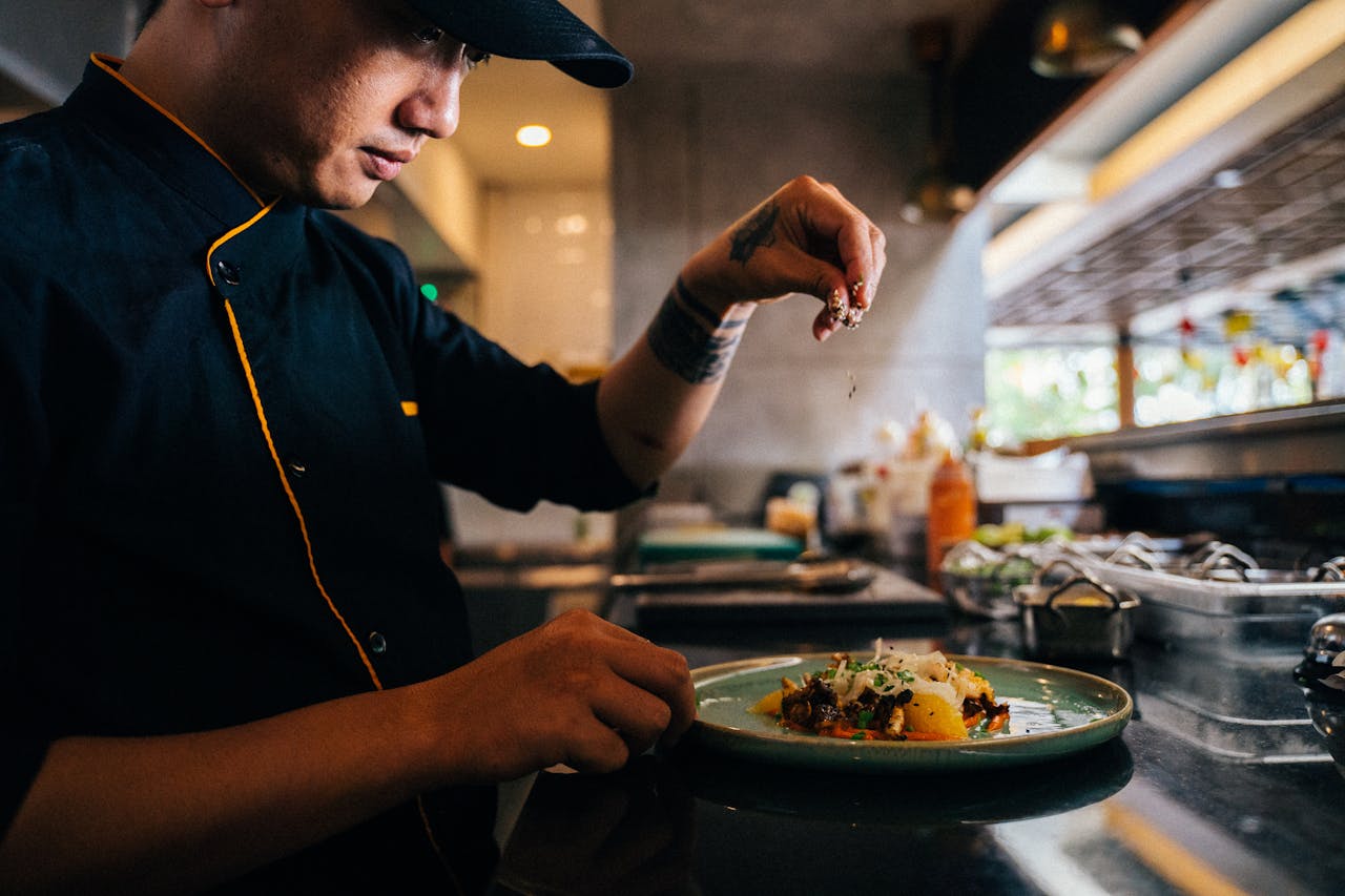 ine dining chef plating dish dramatic lighting