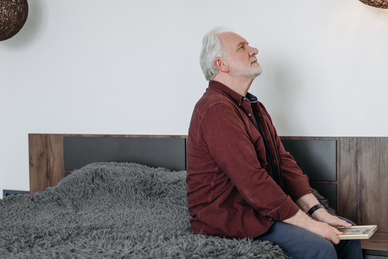 elderly parent sitting alone thinking sad
